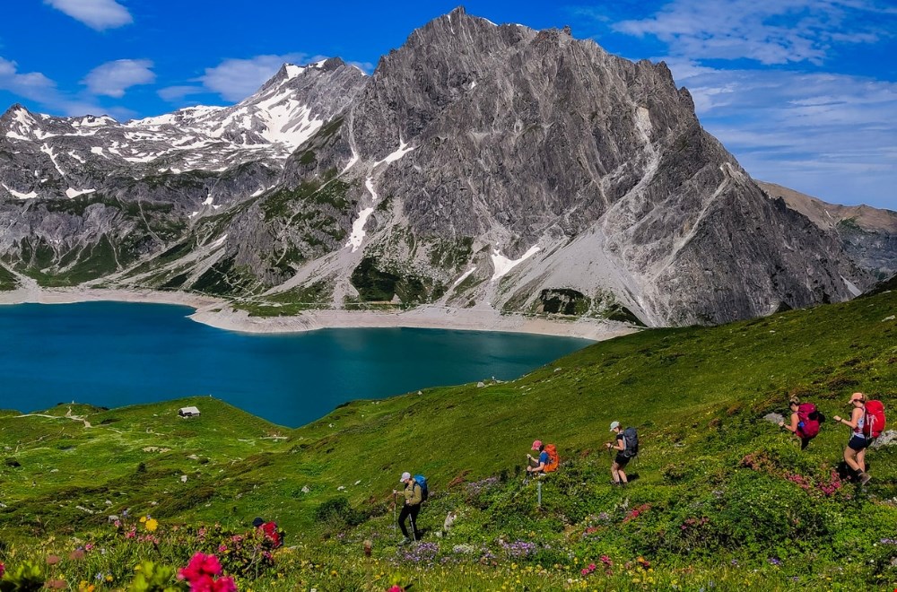 Vrouwen tijdens een huttentocht in de bergen met rugzakken en uitzicht op berglandschap