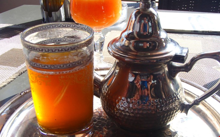 In Marokko drinken ze graag muntthee die geschonken wordt uit een speciale theepot en bijbehorende glazen In Marokko drinken ze graag muntthee die geschonken wordt uit een speciale theepot en bijbehorende glazen