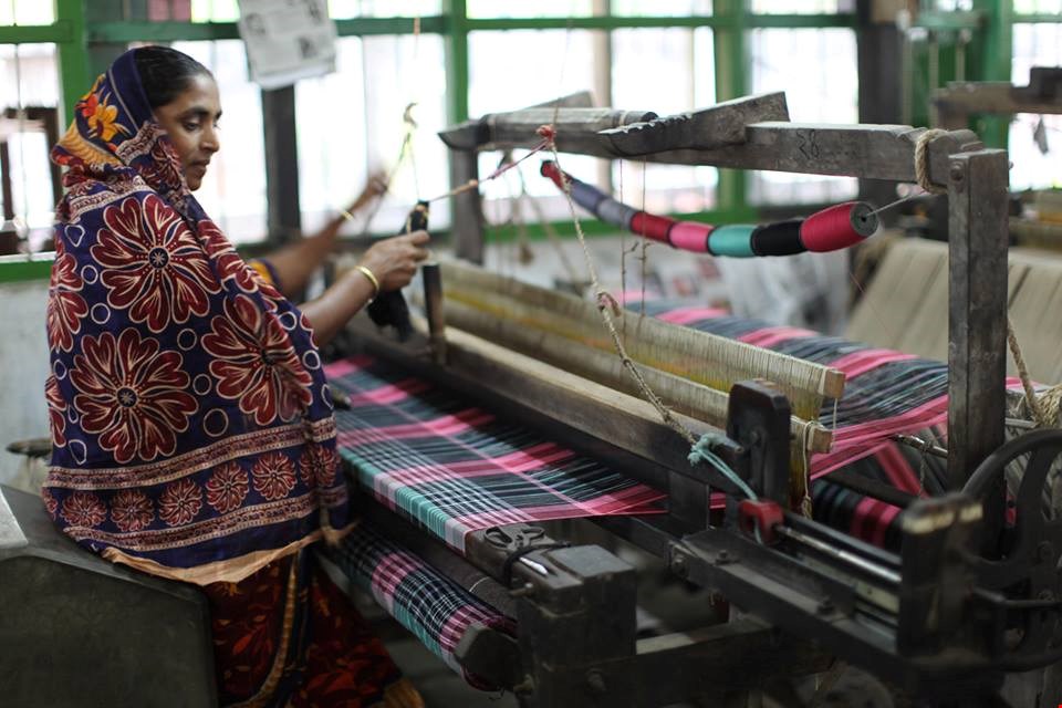 Een Indiase vrouw weeft stoffen voor de duurzame mode-industrie Een Indiase vrouw weeft stoffen voor de duurzame mode-industrie