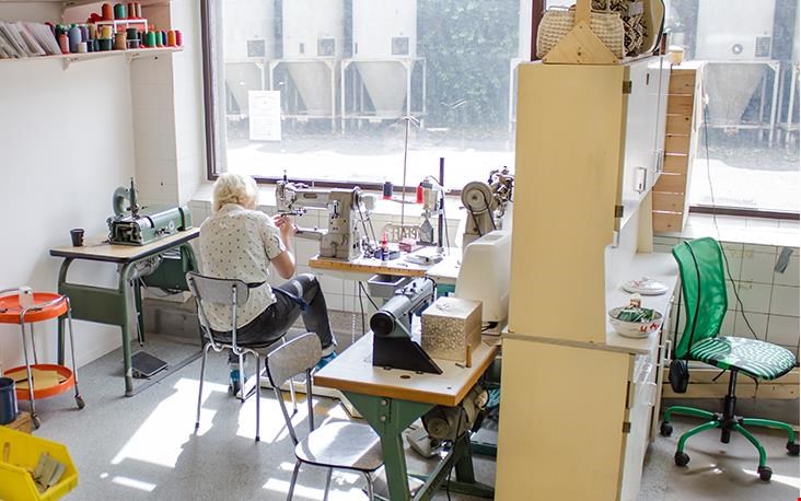 Bij binnenkomst tref ik Anna werkend achter de naaimachine aan Bij binnenkomst tref ik Anna werkend achter de naaimachine aan